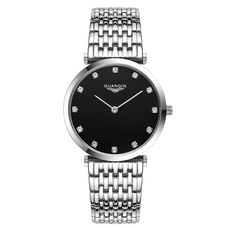 Silver watch with black face and diamond-like stones on a white background