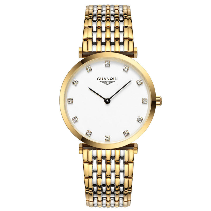 Gold watch with a white face and diamond-like accents on a white background
