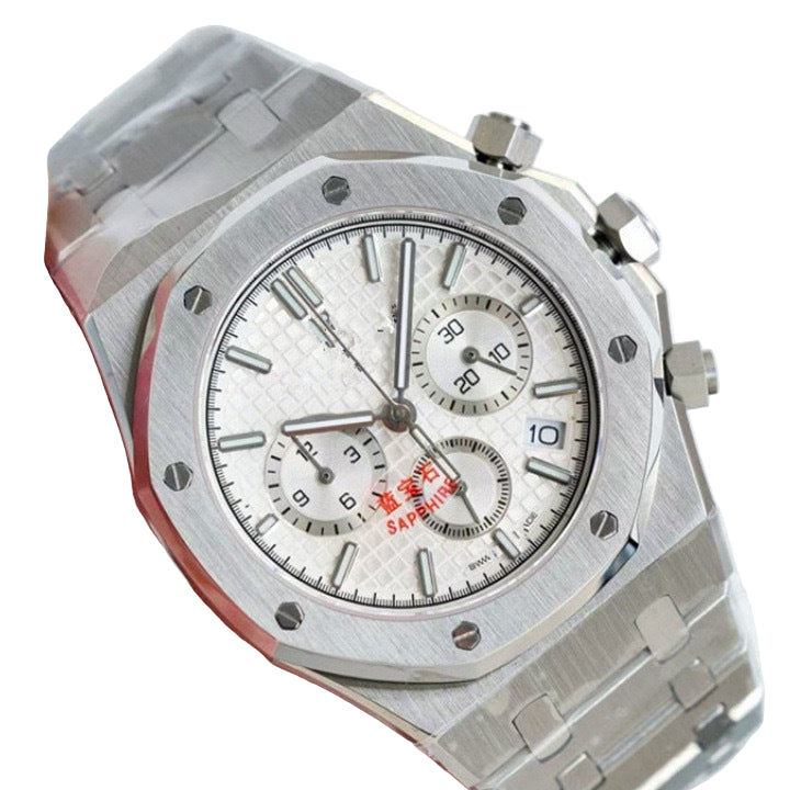 Silver watch with a detailed face held by a hand against a white background