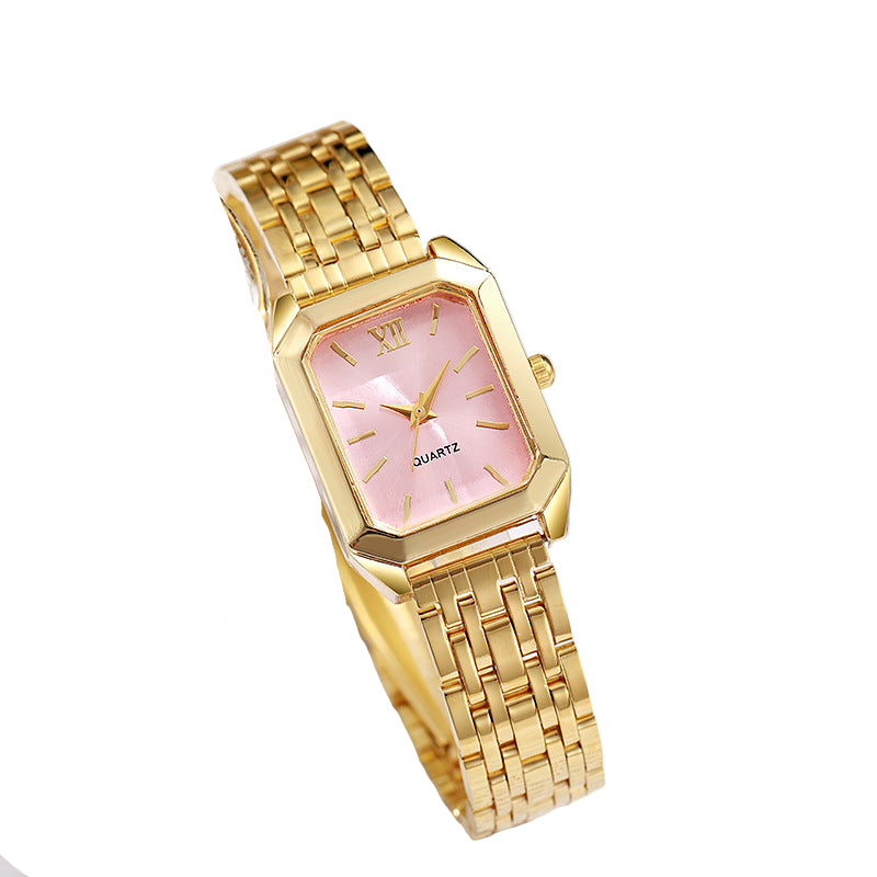 Gold wristwatch with pink face on a surface with text
