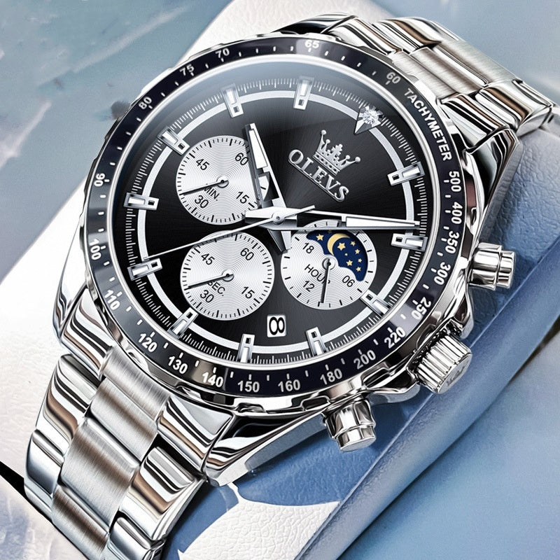 Silver watch with black dial on a light blue background