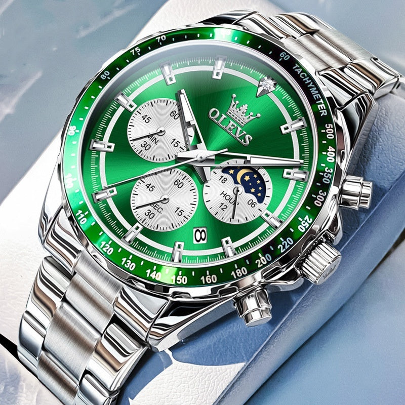Green watch with silver case and band on a light blue background