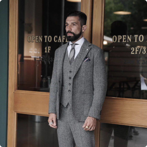 Man in a gray suit standing in front of a store entrance