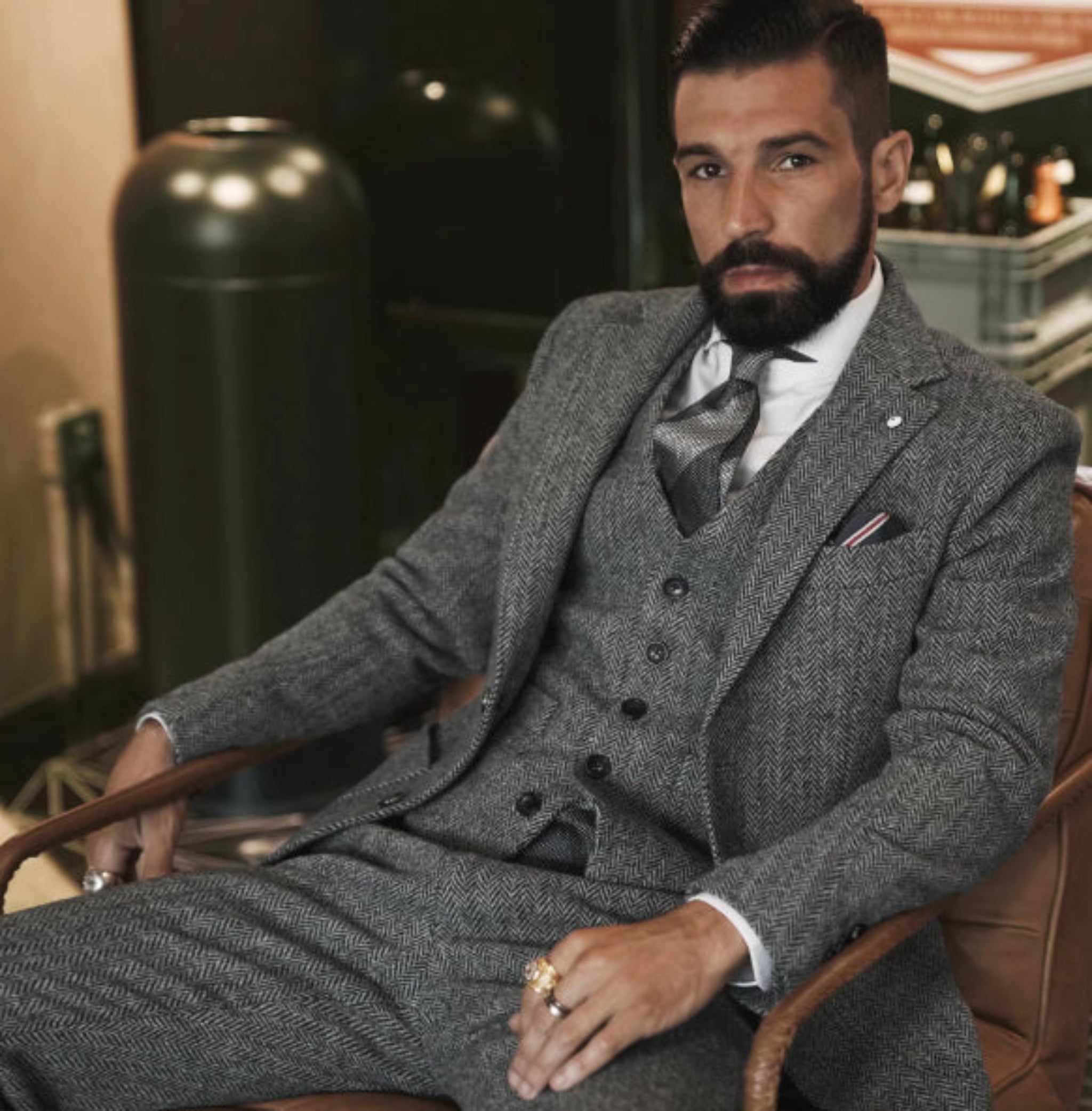 Man in a gray suit sitting in an elegant room