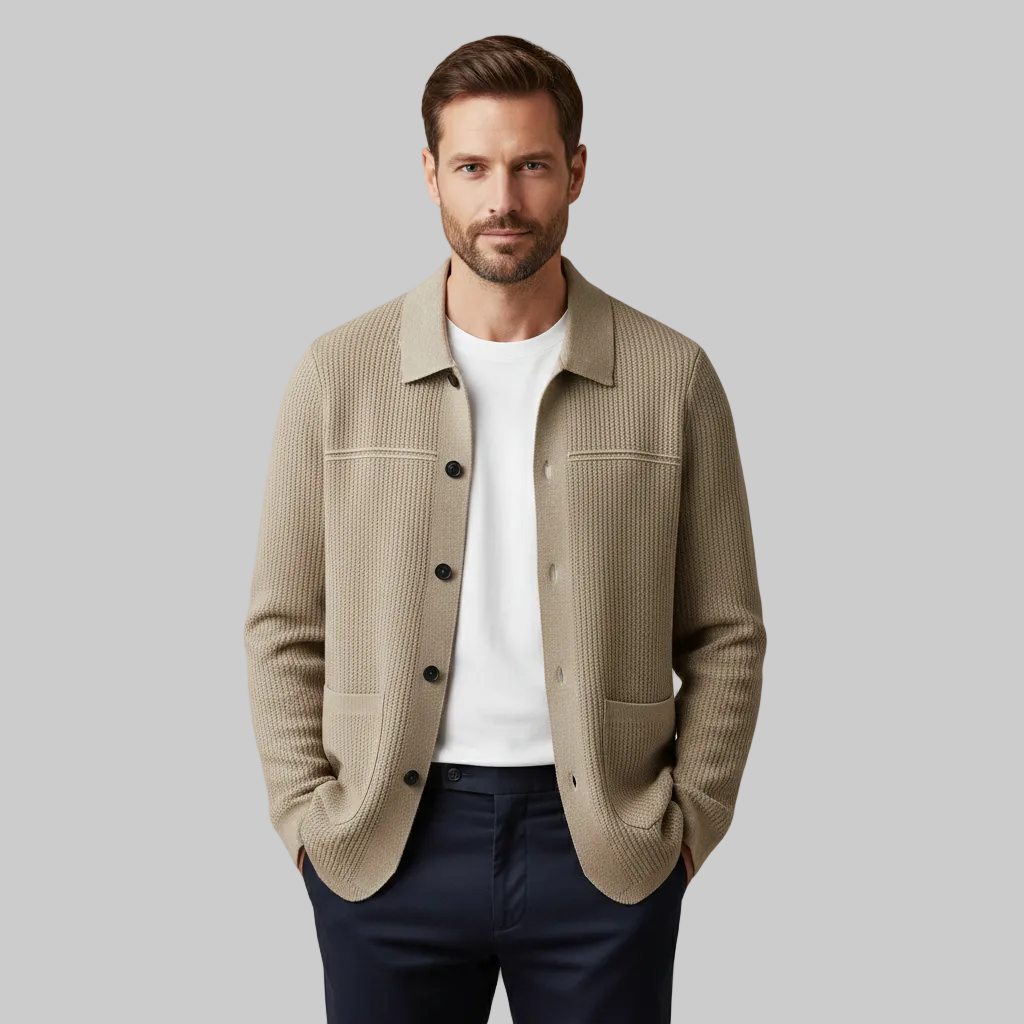 Man wearing a beige jacket over a white shirt with a neutral background