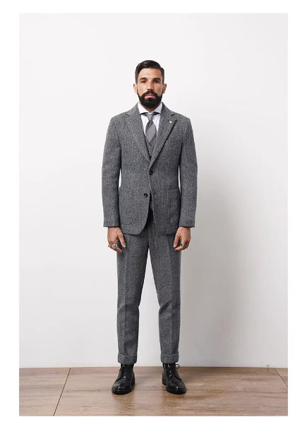 Man wearing a gray suit with a white shirt and tie against a white background